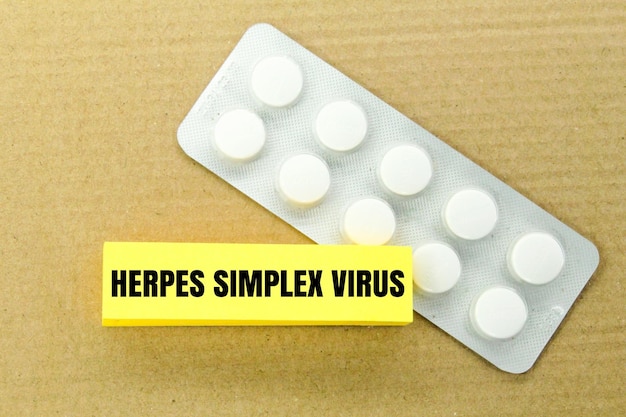 Foto medicamento e papel colorido com a palavra vírus herpes simplex conceito de doença viral