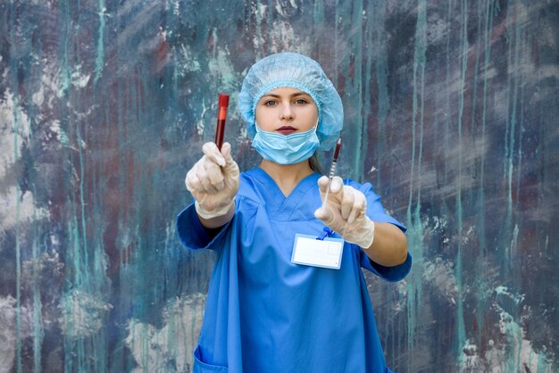 Medicamento. Mujer médico en uniforme protector con máscara en la cara con jeringa