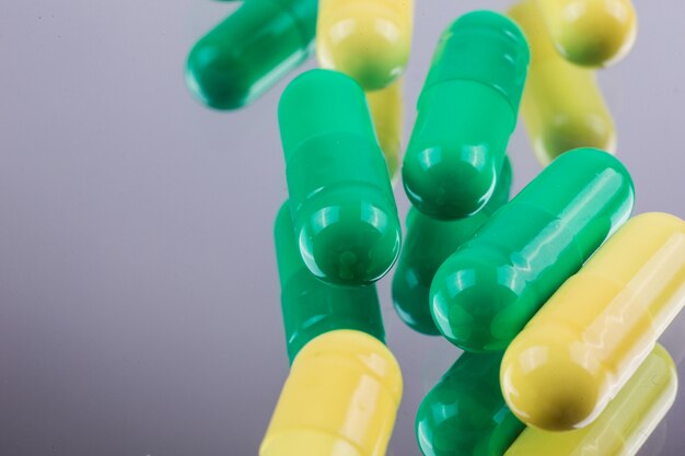Medicamentos cápsulas amarelas e verdes