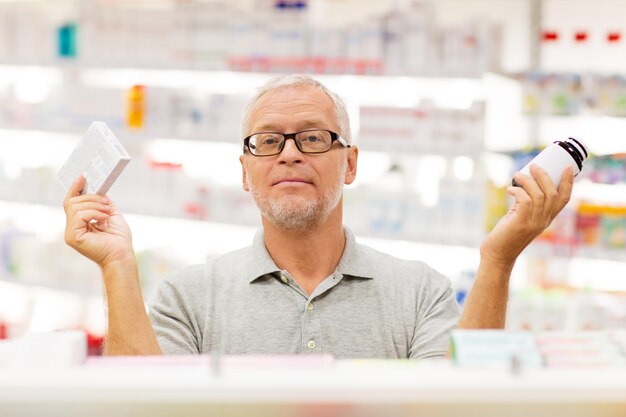 Foto medicamentos farmacéuticos atención médica y conceptos de personas cliente masculino de edad avanzada que elige entre medicamentos en la farmacia