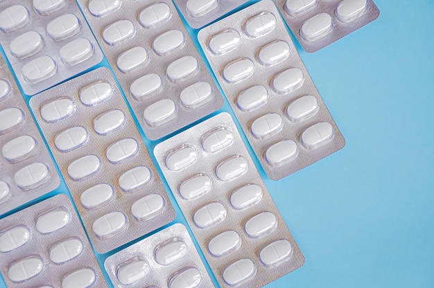 Medicamentos farmacéuticos y píldoras de medicamentos en paquetes en ba azul