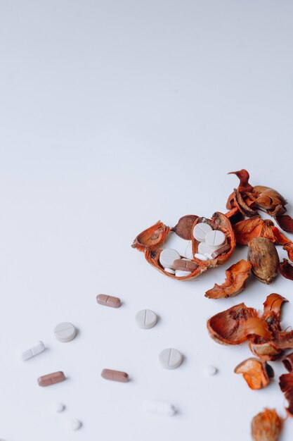 Medicamentos y flores secas de color naranja sobre fondo blanco Copiar espacio para el concepto de salud y belleza