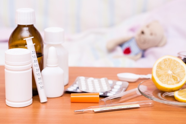 Medicamentos en la mesa cama infantil con un peluche