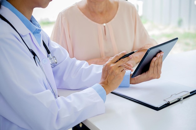 Medição de um médico mostrando um tablet digital a uma paciente no hospital