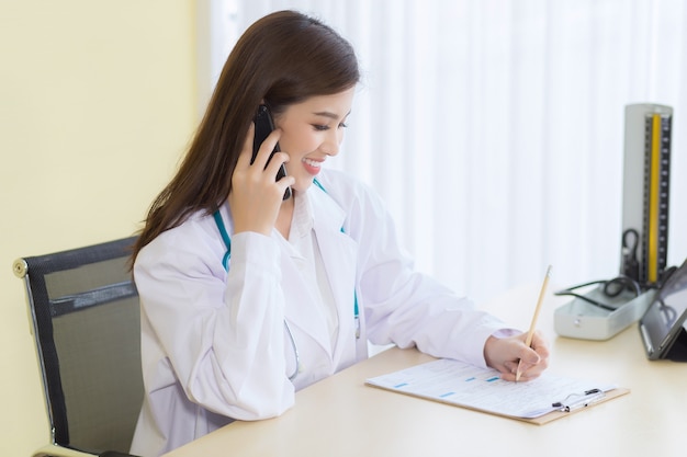 Médicas asiáticas fornecem aconselhamento por telefone. Conceito de proteção do Coronavírus.