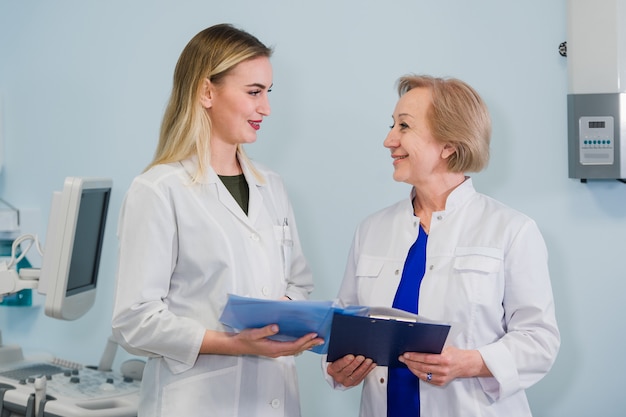 Médicas conversando e segurando documentos