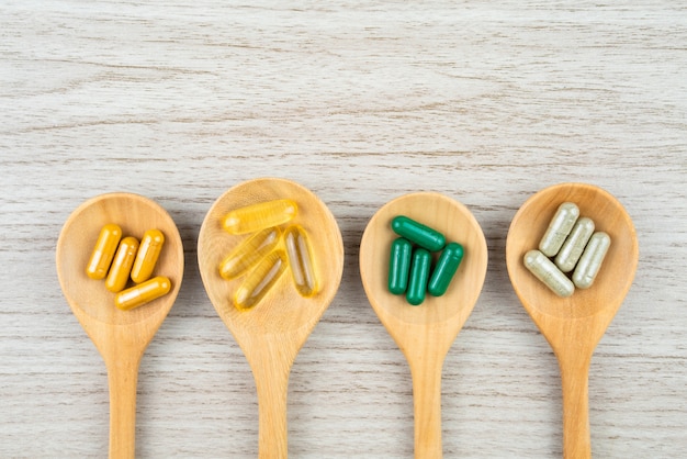 Medicina alternativa a base de hierbas en cápsulas en mesa de madera con espacio de copia para el fondo médico