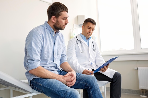 Foto medicina atención médica y concepto de personas médico con clipboard y joven paciente masculino con problemas de salud reunión en el hospital