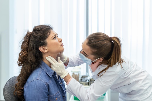 Foto medicina cuidados de saúde e conceito de exame médico médico ou enfermeiro verificando os pacientes amígdalas no hospital endocrinologista examinando a garganta de uma jovem mulher na clínica