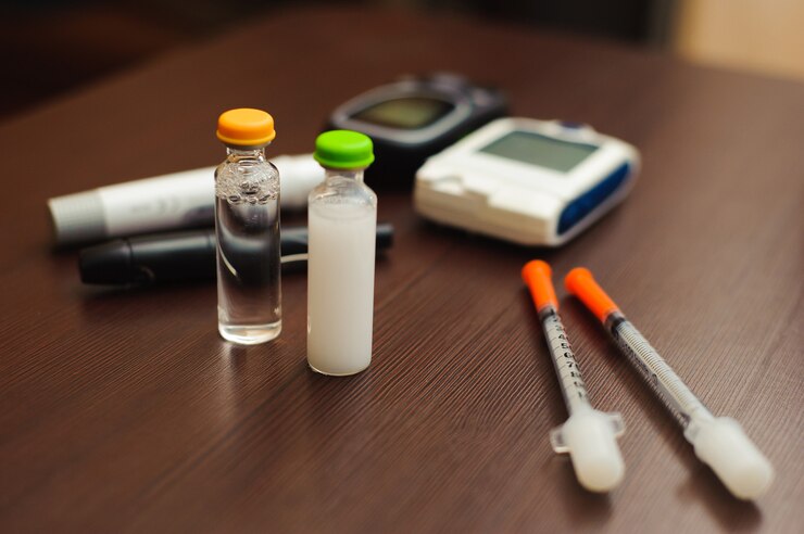 Foto medicina, diabetes e conceito dos cuidados médicos - próximo acima da tira de teste do açúcar no sangue, do glucometer, da caneta da insulina e de outras ferramentas diabéticas na tabela.