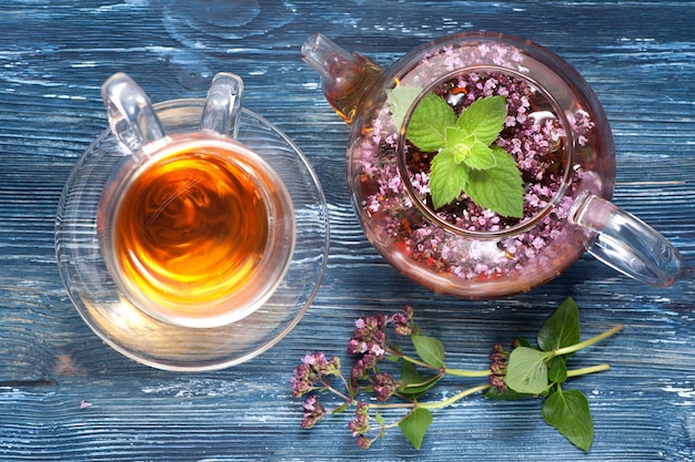 Medicina herbaria Té de hierbas con orégano y menta sobre un fondo azul horizontal