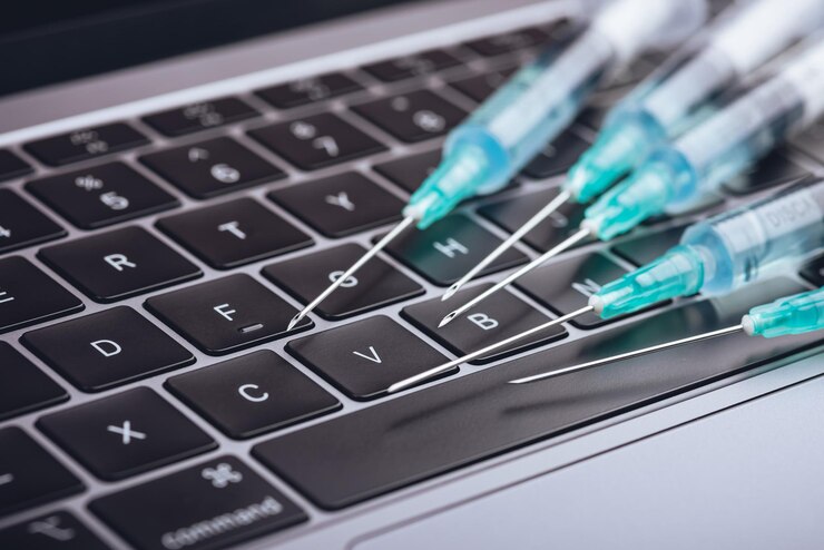 Foto medicina un montón de jeringas diferentes en una computadora portátil gris oscuro