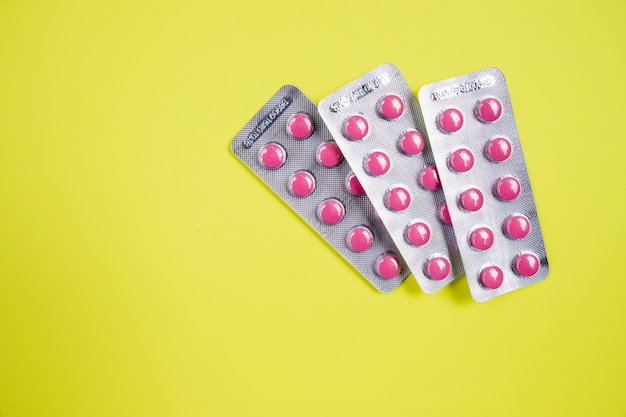 Foto medicina pastillas ampollas paquetes pila. tema de la farmacia, el montón de pastillas antibióticas tableta redonda de medicina de color rosa.