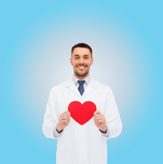 medicina, profesión y concepto de salud - médico sonriente con corazón rojo