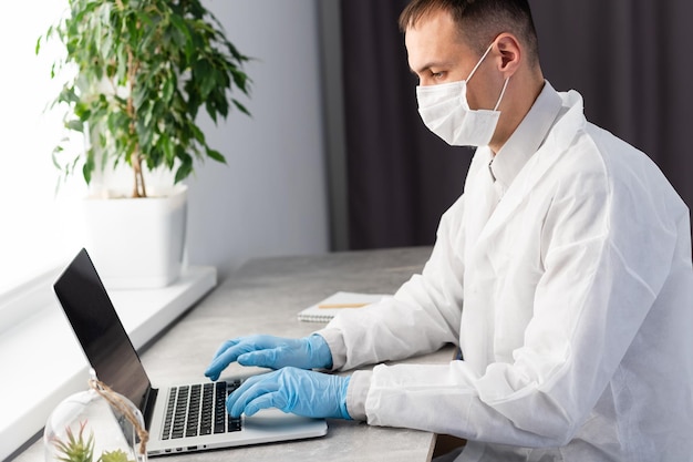 medicina, profissão, tecnologia e conceito de pessoas - médico masculino sorridente com laptop no consultório médico.