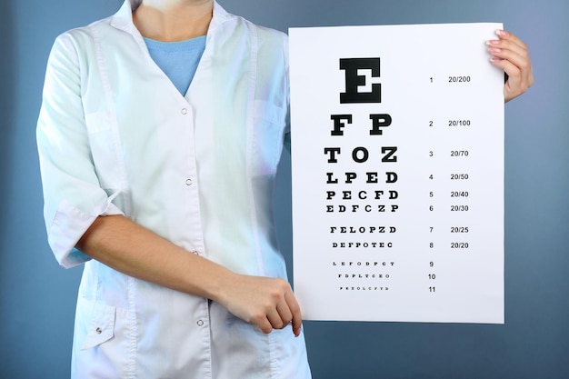 Medicina de salud y concepto de visión mujer con tabla optométrica sobre fondo de color