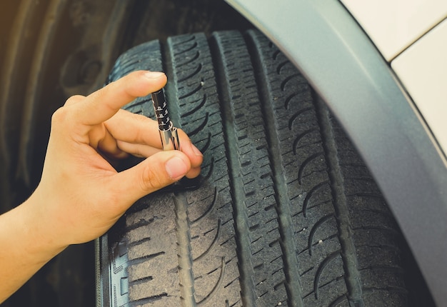 Medición del desgaste de la banda de rodadura en un neumático de un automóvil. Seguro de usar a diario.