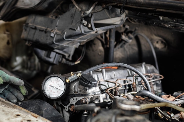 Foto medición de la presión de compresión en los cilindros de un motor de automóvil.