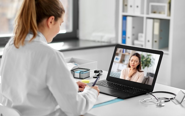 médico a fazer uma chamada de vídeo com o paciente no portátil