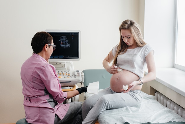 Un médico aconseja a una niña embarazada después de una ecografía en la clínica. Examen medico