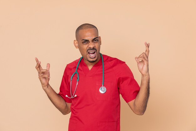 Médico africano enojado vistiendo un uniforme rojo blanco