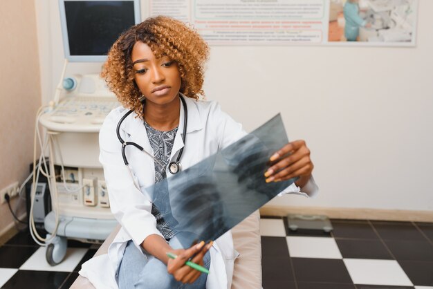 Médico africano examinando radiografia de paciente no hospital