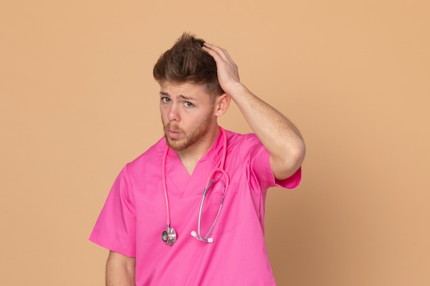 Médico africano vistiendo un uniforme rosa sobre un fondo amarillo