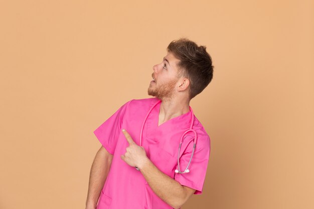 Médico africano vistiendo un uniforme rosa sobre un fondo amarillo