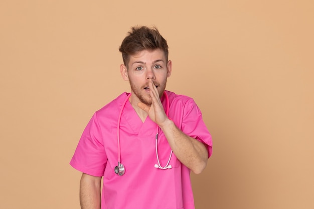 Médico africano vistiendo un uniforme rosa sobre un fondo amarillo