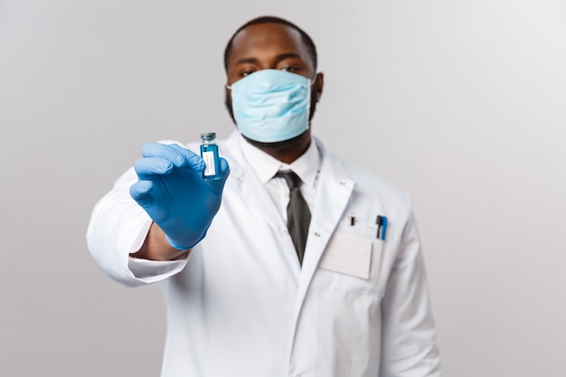 Médico afro-americano de retrato em uniforme branco.