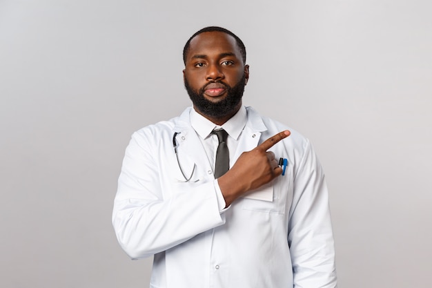 Médico afro-americano de retrato em uniforme branco.