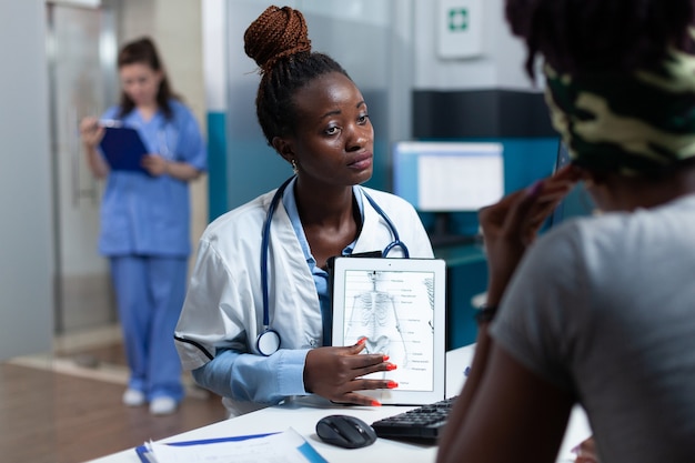 Médico afro-americano explicando radiografia