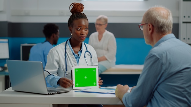 Médico afro-americano falando sobre tecnologia de tela verde