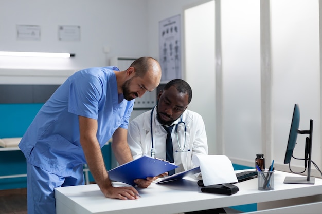 Médico afroamericano explicando la experiencia de la enfermedad comprobando la prescripción de medicamentos