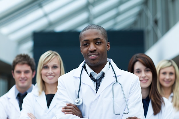 Médico afroamericano liderando a su equipo con los brazos cruzados