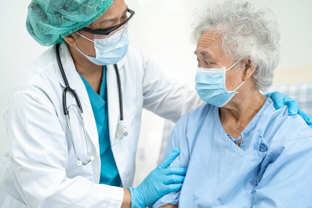 Foto médico ajuda anciã asiática ou idosa mulher paciente usando uma máscara facial no hospital para proteger a infecção de segurança e matar covid-19 coronavirus