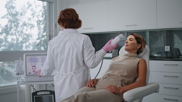 Médico ajustando equipamentos de cosmetologia para tratamento de ultrassom na clínica