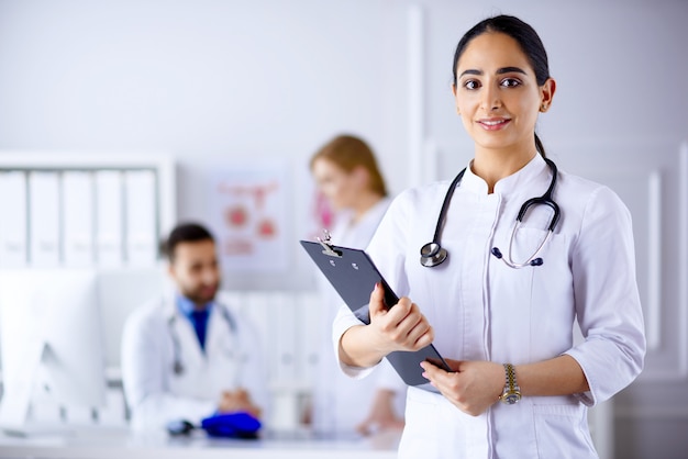 Médico árabe em pé na frente de sua equipe no hospital