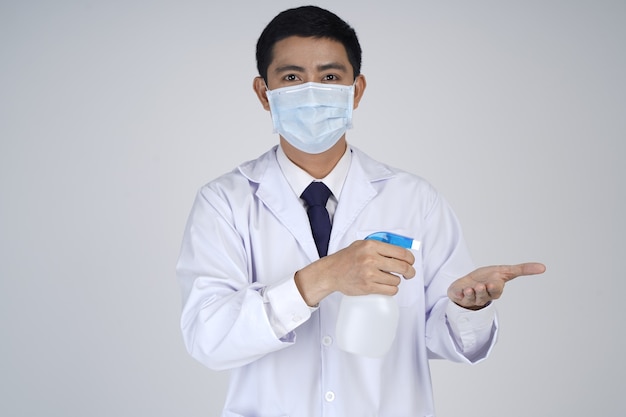 Médico asiático com máscara médica, mostrando o frasco do produto