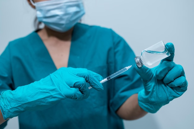 Foto médico asiático com seringa e vacina para proteger o vírus covid19 em fundo branco