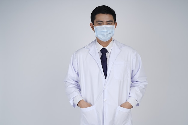 Médico asiático hombre vestido con bata blanca y máscara médica