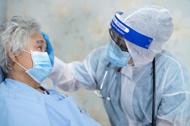 Médico asiático con protector facial y EPP se adapta a la nueva normalidad para proteger el coronavirus Covid19