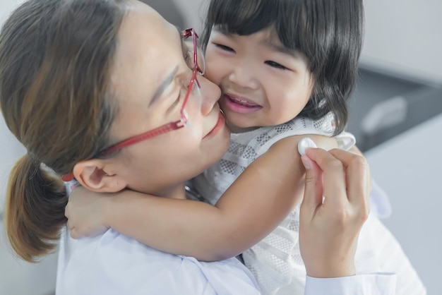 Un médico asiático que usa un estetoscopio para comprobar su respiración y el corazón de una chica encantadora comprueba la salud de los niños de Tailandia