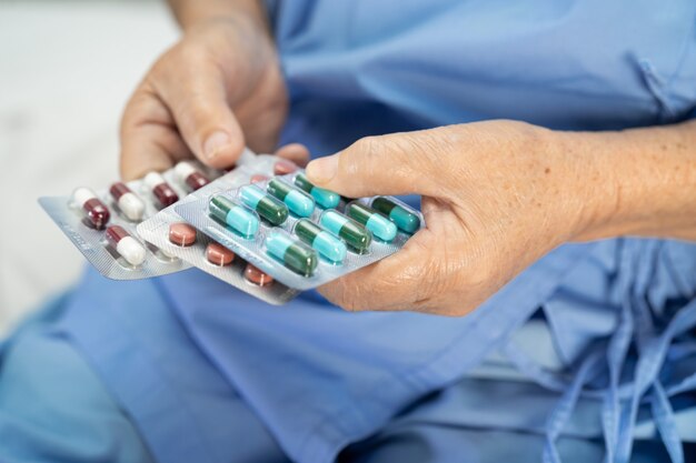 Médico asiático segurando remédios de comprimidos.