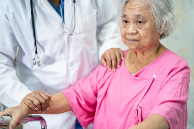 Médico asiático tocar paciente mujer mayor asiática con amor.