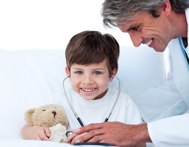 Foto médico atento brincando com um garotinho