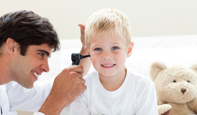 Médico atraente verificando as orelhas do paciente