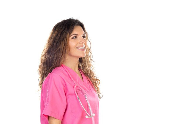 Médico atraente vestindo um uniforme rosa isolado em um fundo branco