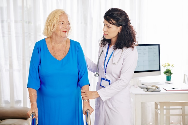 Médico ayudando a mujer mayor