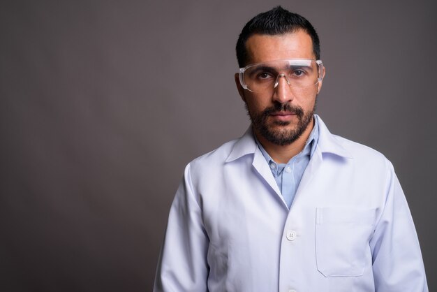 Médico barbudo bonito usando óculos de proteção a
